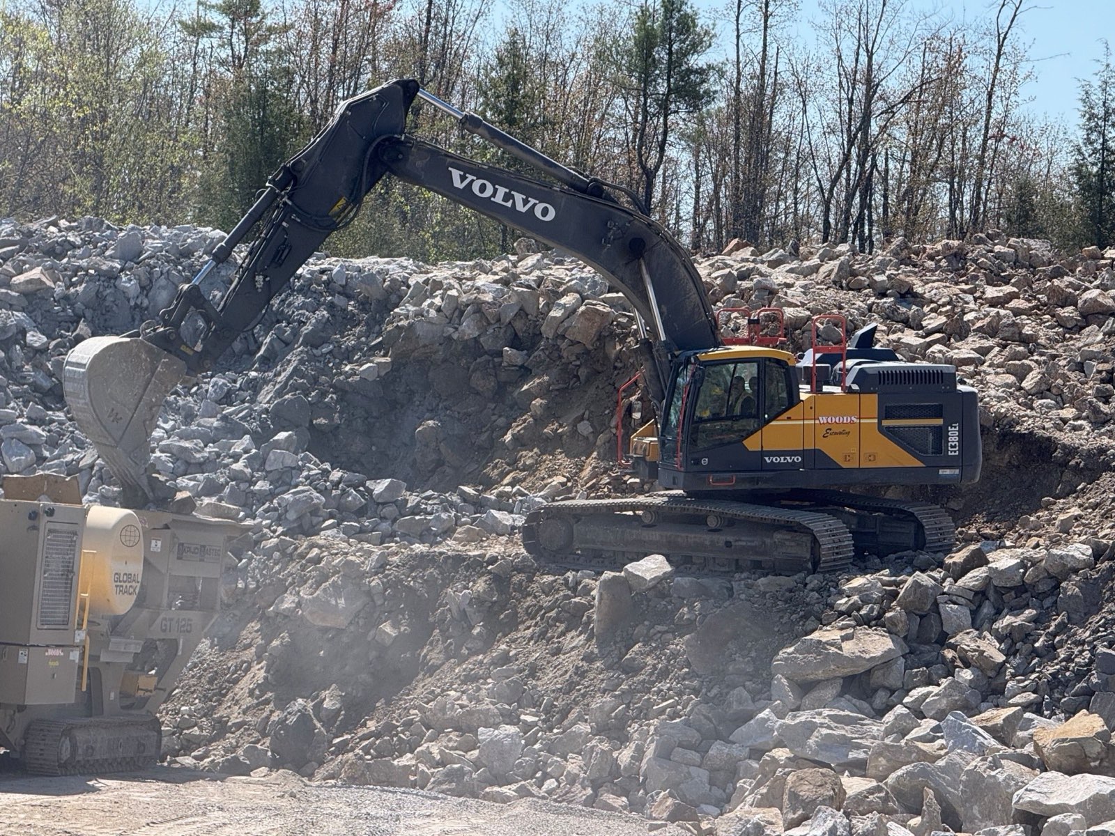 Woods Volvo EC380EL feeding a jaw crusher on site, operator in hi-vis