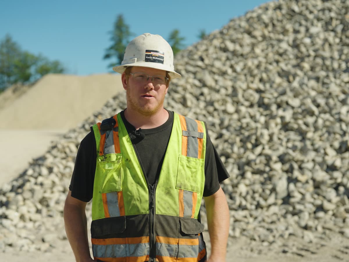 Kevin McKenney in a white hard hat and hi-vis vest at the Baxter Pit stockpiles